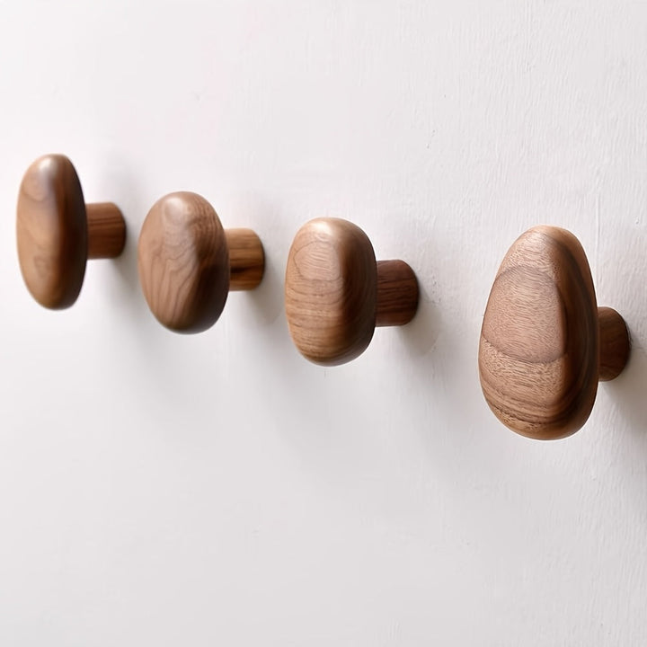 Four wooden wall hooks on a white background