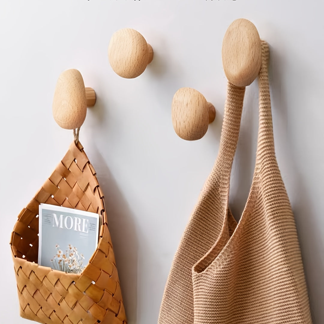 Wooden wall hooks with a woven bag and magazine on a light gray background