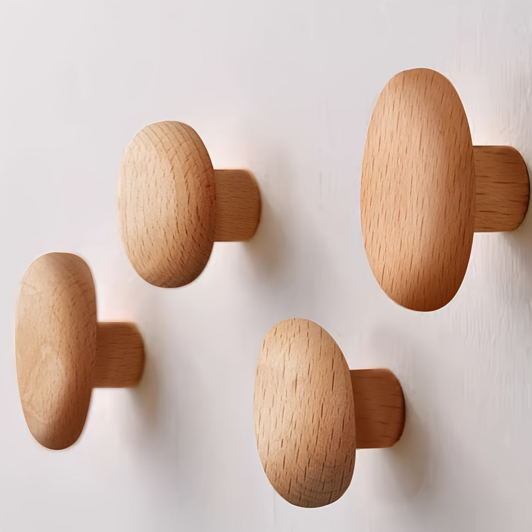 Four wooden wall hooks on a light gray background