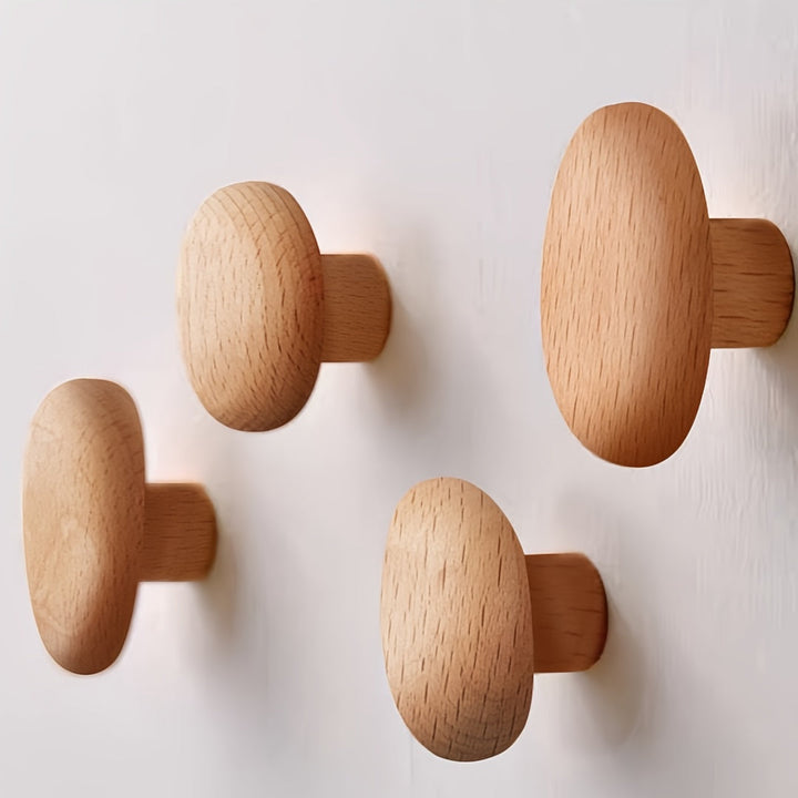 Four wooden wall hooks on a light gray background