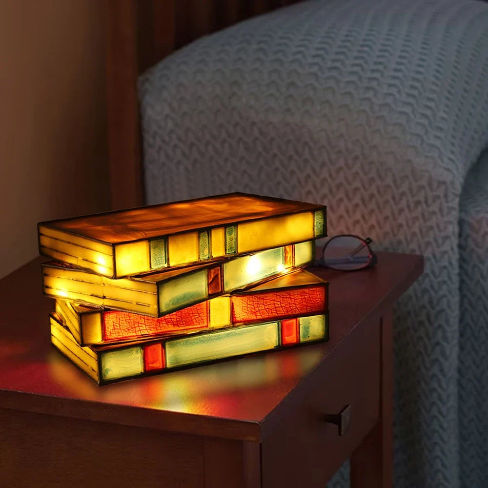Stack of colorful books illuminated as a lamp on a wooden surface with a soft background