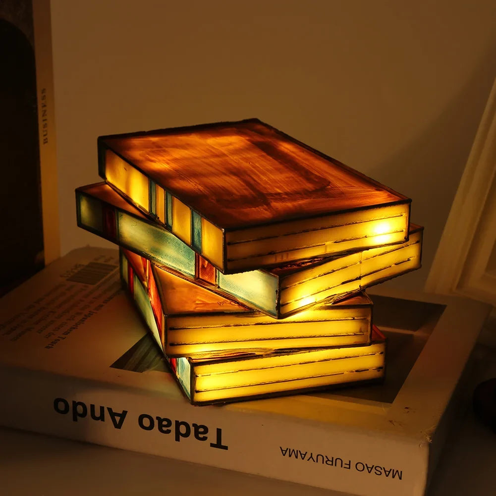 Stack of books shaped like a lamp on a book with 'Taddeo Ando' visible