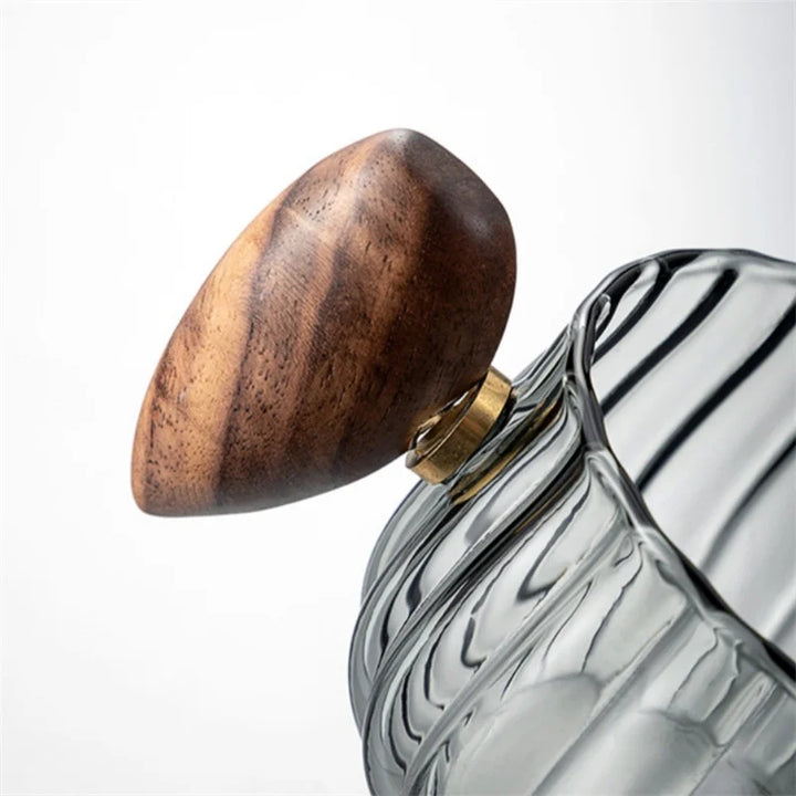 Glass container with wooden and brass lid on a white background