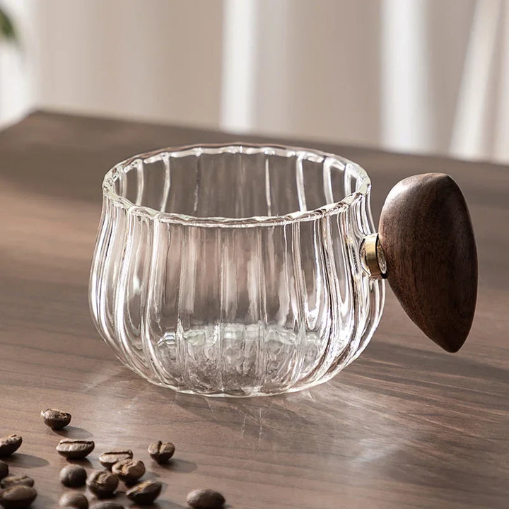 Clear glass container with wooden lid on a wooden surface with coffee beans.