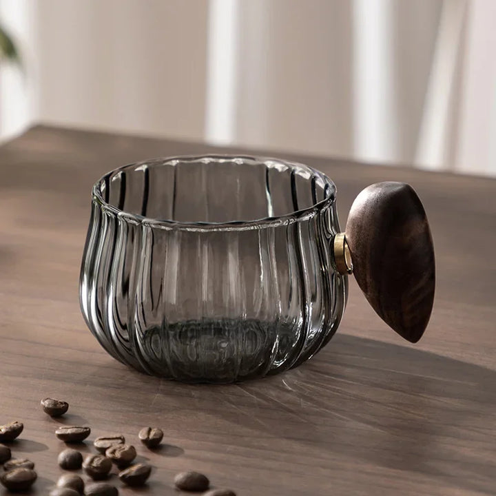 Glass container with wooden lid on a wooden surface with coffee beans