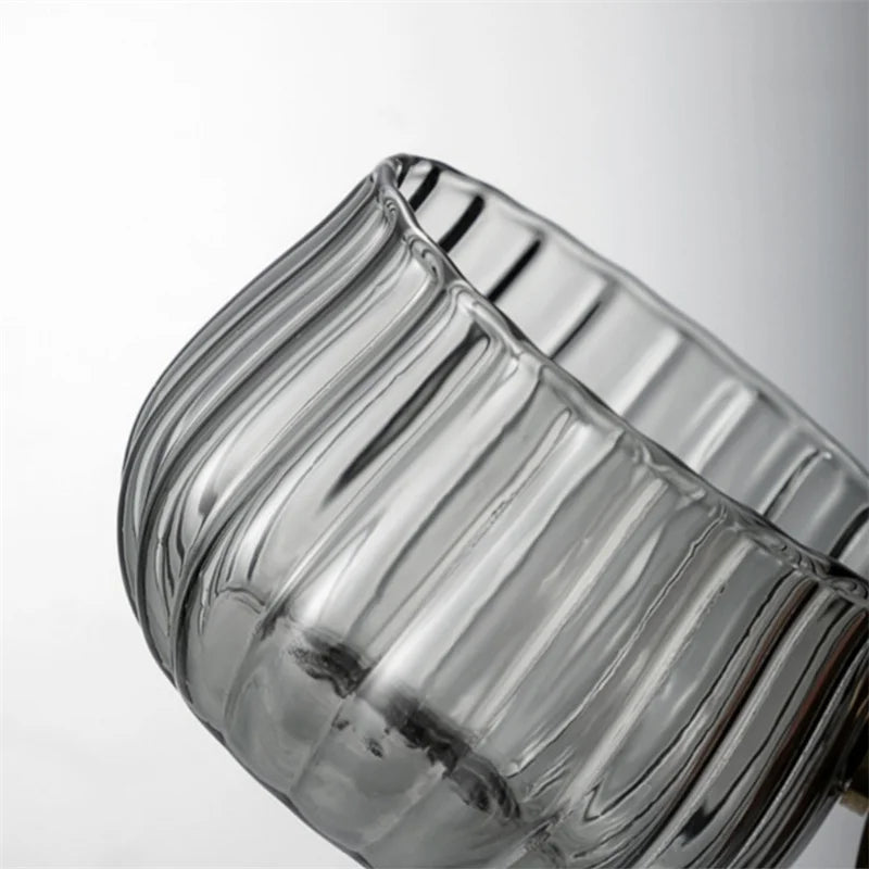 Clear glass candle holder with ribbed design on a white background