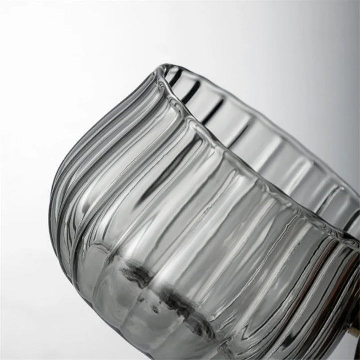 Clear glass candle holder with ribbed design on a white background
