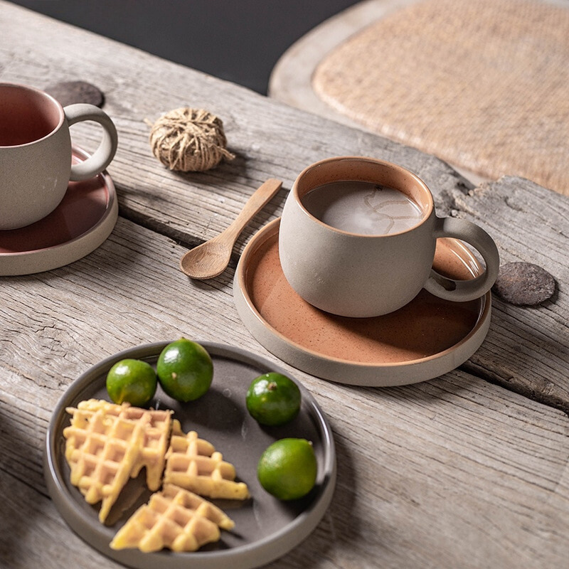 Ceramic cups and saucers with waffles and limes on a wooden surface, featuring the brand 'Flowerherd'.