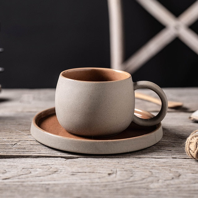 Ceramic cup and saucer set on a wooden surface with a dark background