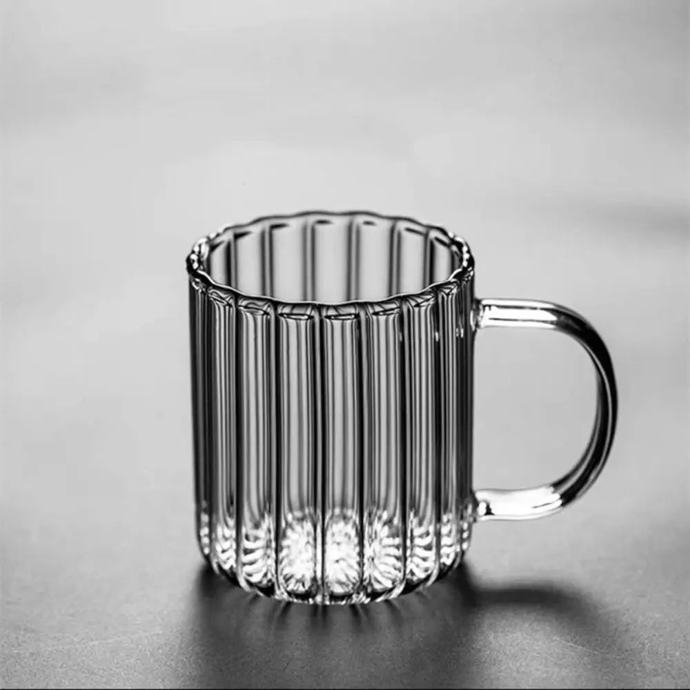 Clear glass mug with ribbed design on a gray background