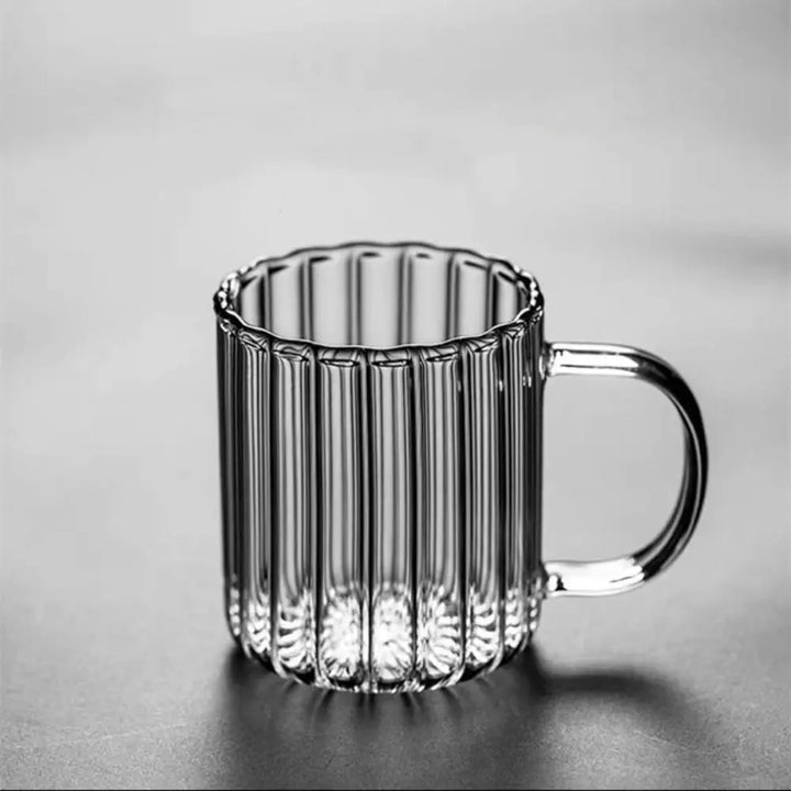 Clear glass mug with ribbed design on a gray background