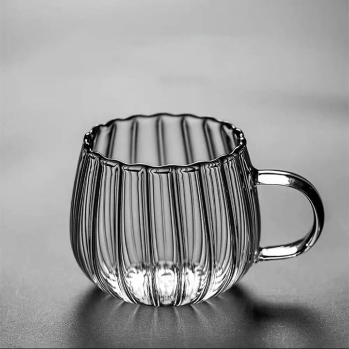 Clear glass mug with ribbed design on a gray background