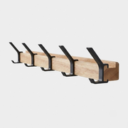 A wall-mounted wooden coat rack with five black metal hooks, shown against a light gray background.