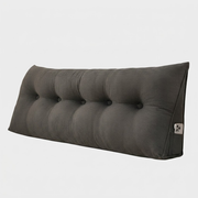 A dark gray tufted lumbar pillow with a triangular backrest, shown on a light gray background.